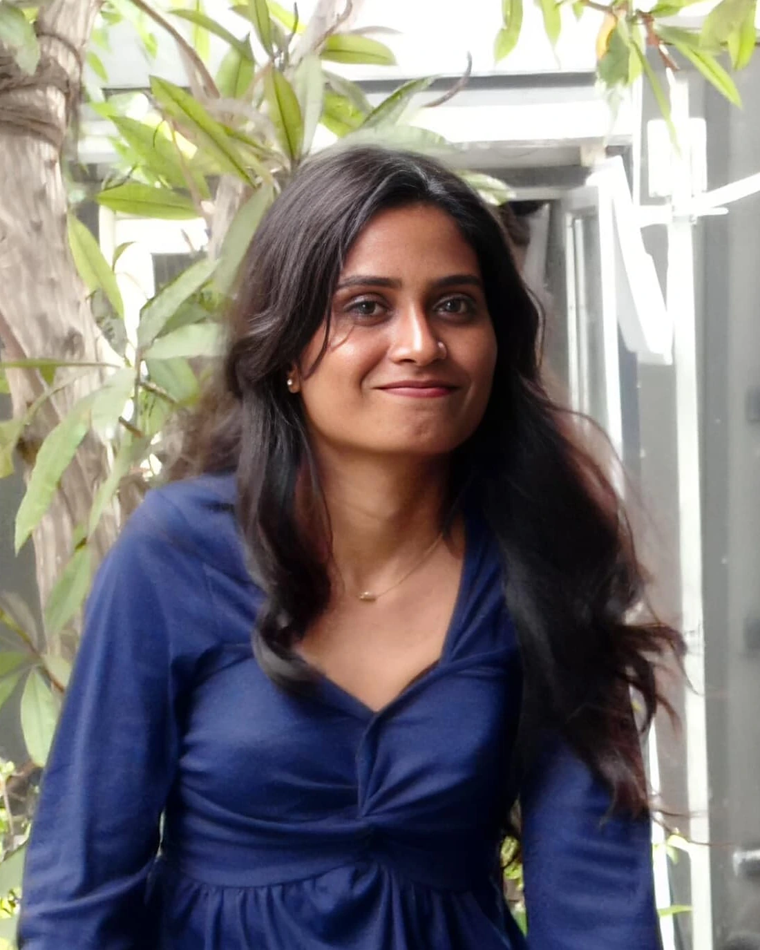 Sree Harini, smiling, in a leafy courtyard